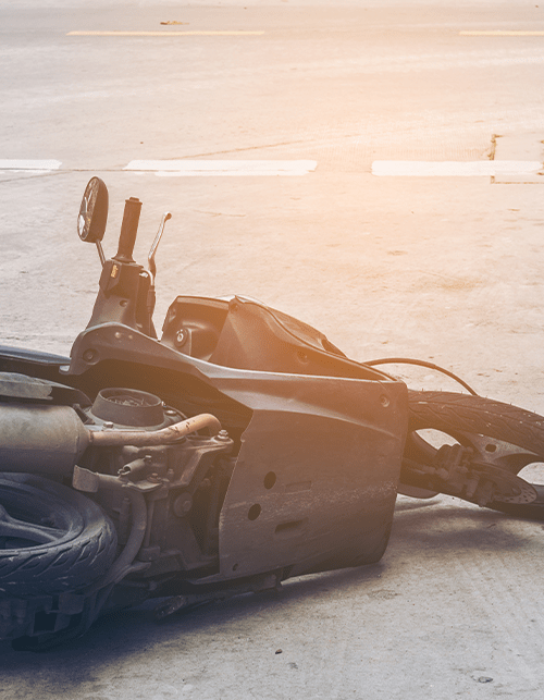 Photo of a crashed motorcycle in the middle of the road.